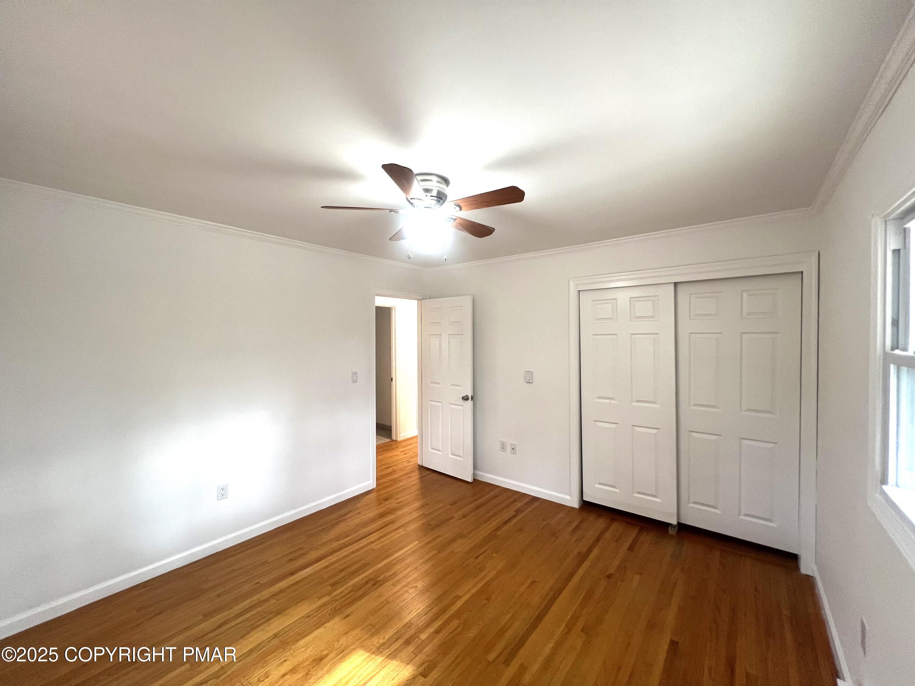 140 Davis Circle Bushkill, PA 18324 - Photo 14 of 31 an empty room with wooden floor and ceiling fan