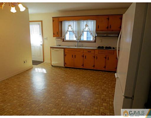 318 New Market Road Dunellen, NJ 08812 - Photo 11 of 23 a kitchen with granite countertop a stove a sink and a refrigerator with wooden floor
