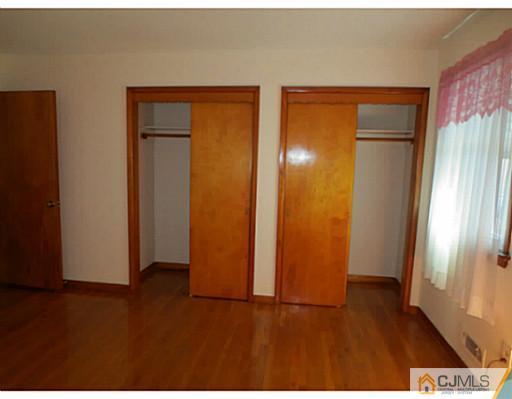 318 New Market Road Dunellen, NJ 08812 - Photo 15 of 23 a view of an empty room with wooden floor and a window