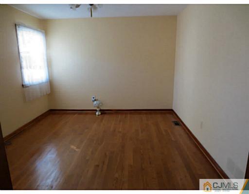 318 New Market Road Dunellen, NJ 08812 - Photo 18 of 23 an empty room with wooden floor and windows