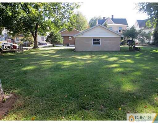 318 New Market Road Dunellen, NJ 08812 - Photo 5 of 23 a big house with a big yard and large trees
