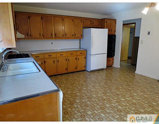 318 New Market Road Dunellen, NJ 08812 - Photo 9 of 23 a kitchen with a refrigerator a stove top oven a sink and dishwasher