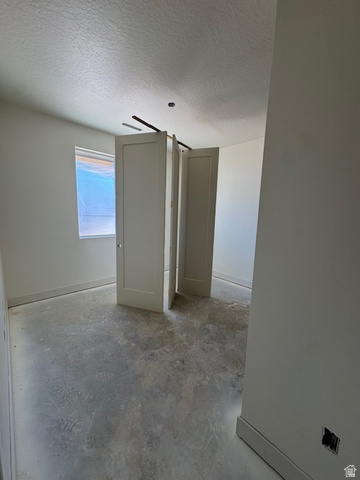 5005 North 75 East Enoch, UT 84721 - Photo 10 of 37 Unfurnished bedroom with concrete flooring and a textured ceiling