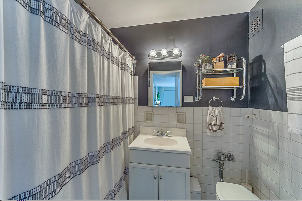 2909 North Sheridan Road, Unit 1012 Chicago, IL 60657 - Photo 9 of 9 a bathroom with a sink and mirror