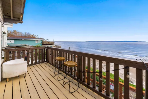a balcony with wooden floor and outdoor seating