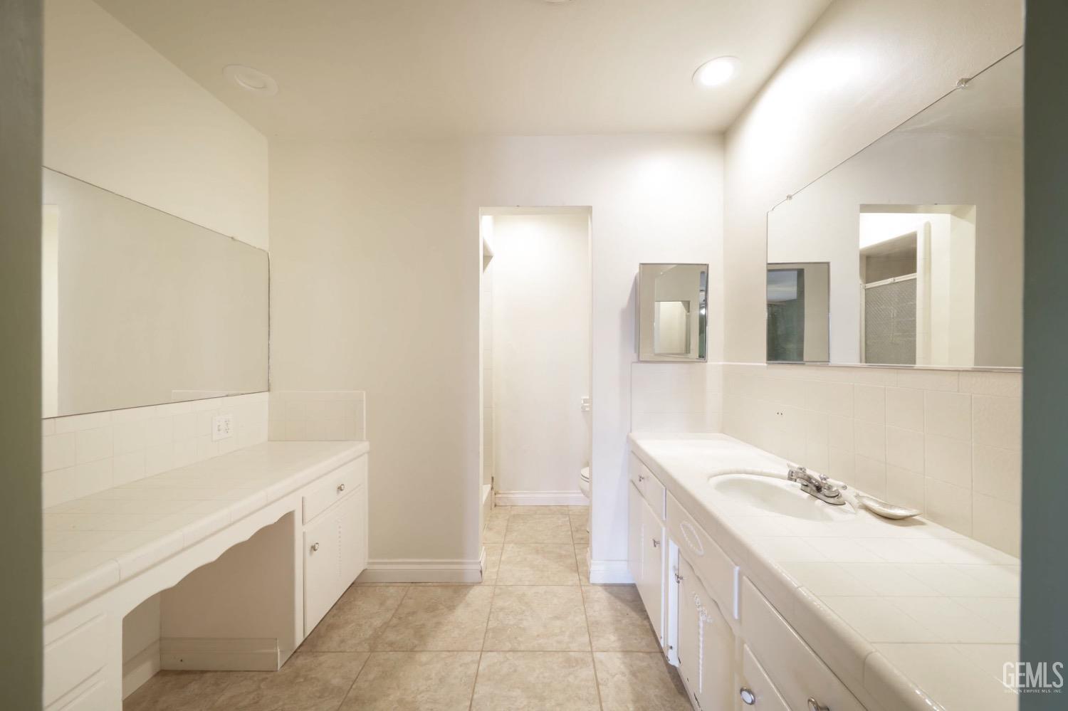 Undisclosed Address Bakersfield, CA 93306 - Photo 7 of 22 a bathroom with a double vanity sink a mirror and a bathtub