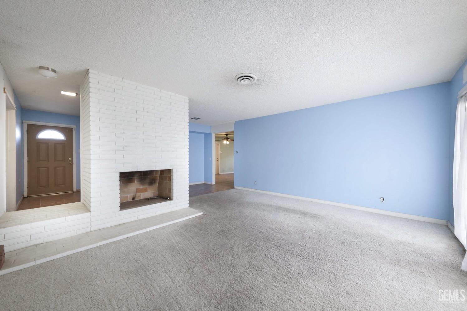 Undisclosed Address Bakersfield, CA 93306 - Photo 10 of 22 a view of an empty room with a fireplace and a window