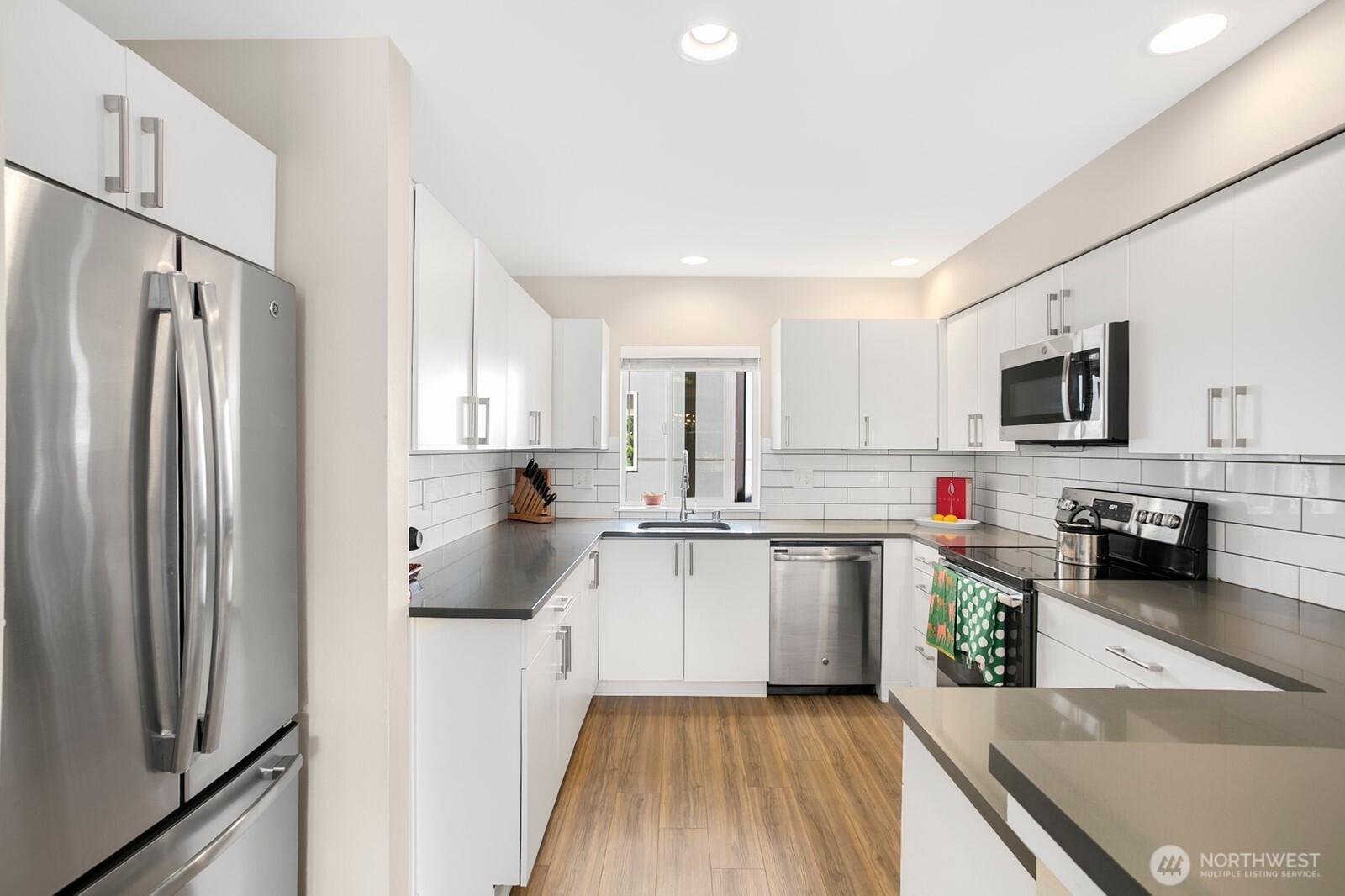 2736 South Andover Street Seattle, WA 98108 - Photo 9 of 24 a kitchen with stainless steel appliances a refrigerator sink and white cabinets