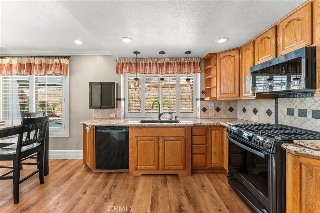 16825 Winterbrook Circle Riverside, CA 92503 - Photo 12 of 42 a kitchen with stainless steel appliances granite countertop a stove a sink dishwasher and a microwave oven with cabinets