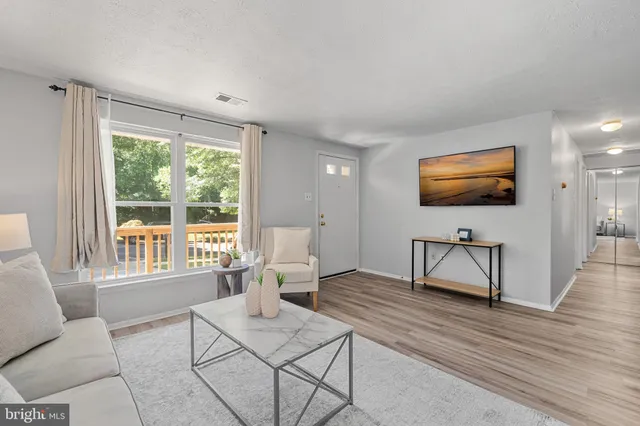 a living room with furniture a flat screen tv and a window