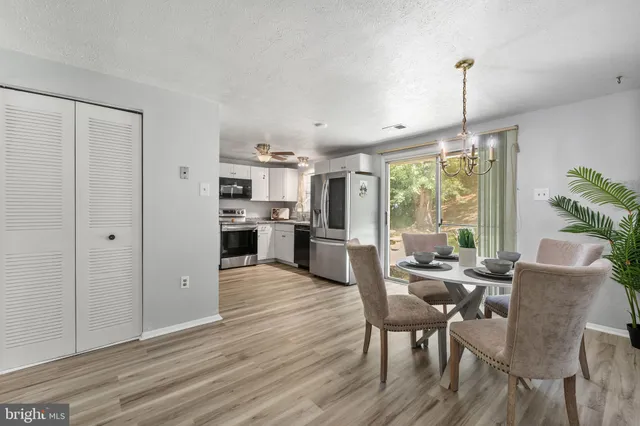 a view of a dining room and livingroom with furniture wooden floor a chandelier