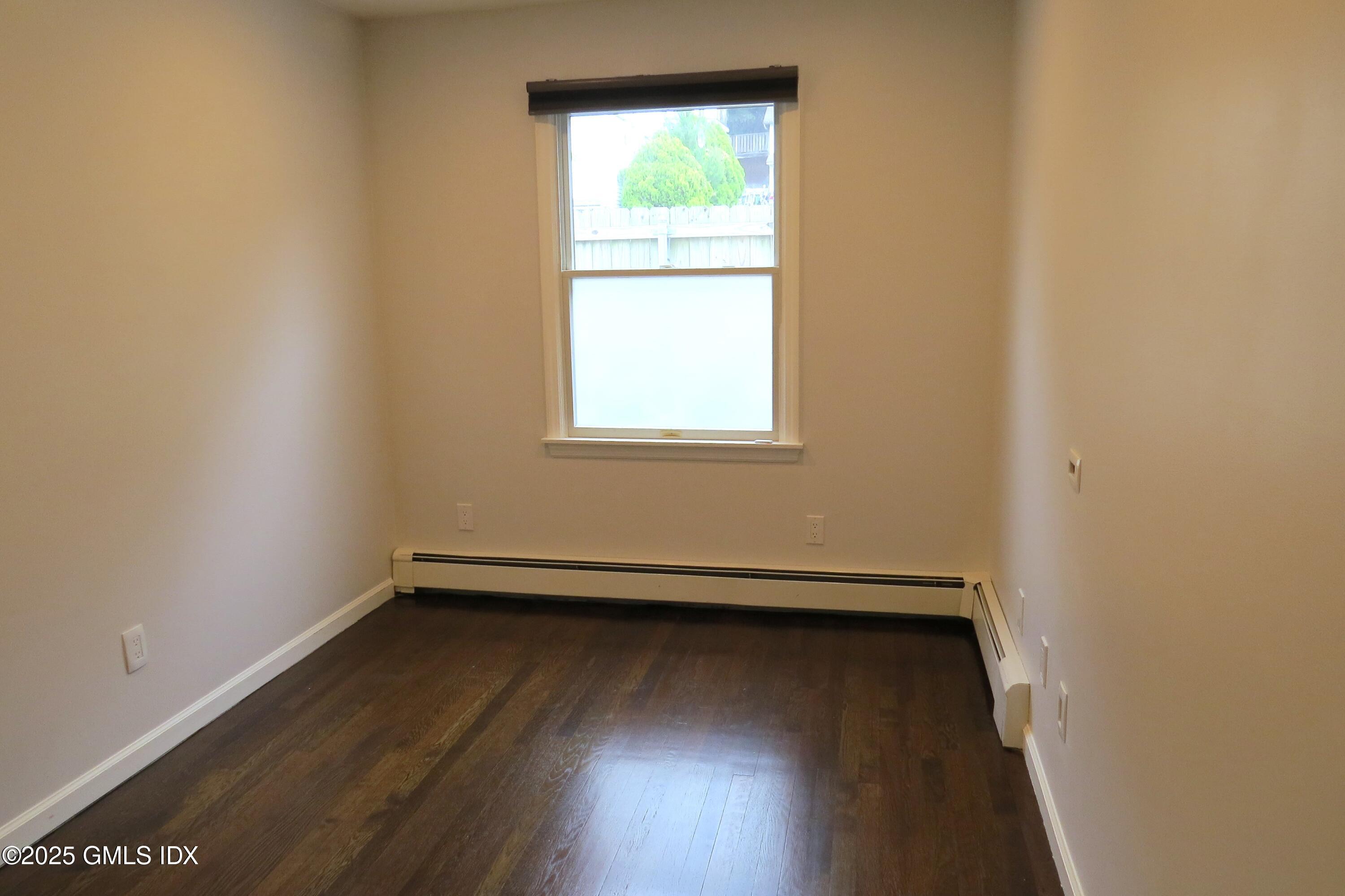68 Pemberwick Road, Unit 1 Greenwich, CT 06831 - Photo 16 of 18 an empty room with wooden floor and windows