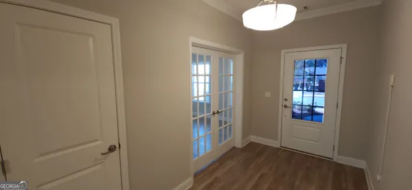 an empty room with wooden floor and windows