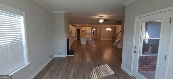 a view of a hallway with wooden floor and a bathroom
