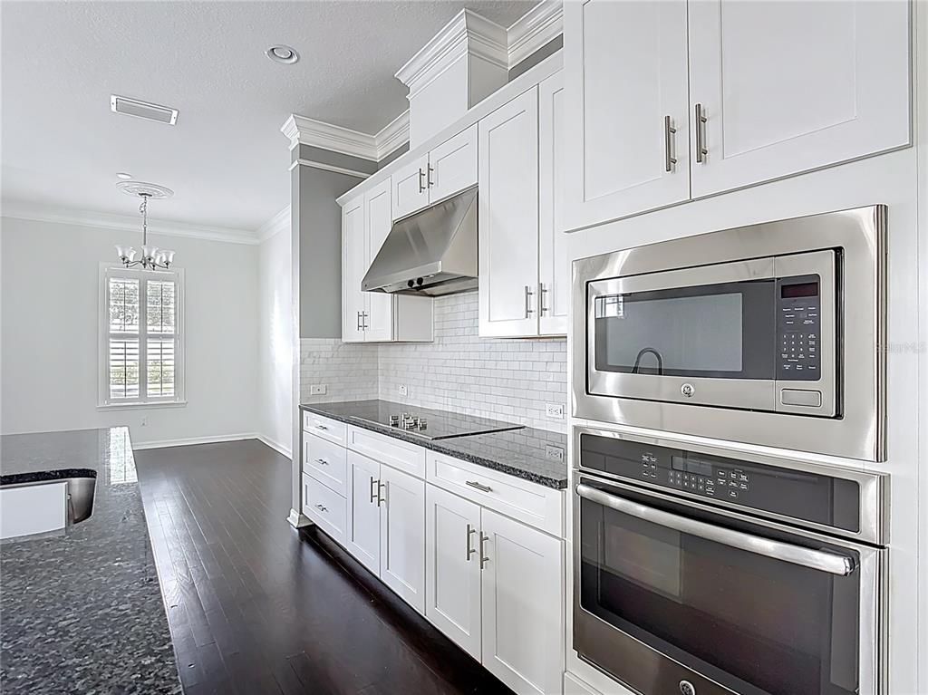 1513 Resolute Street Celebration, FL 34747 - Photo 16 of 43 a kitchen with granite countertop white cabinets stainless steel appliances and sink