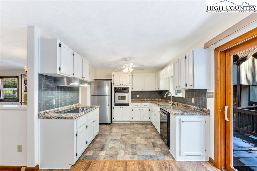 1324 Ripshin Road Troutdale, VA 24378 - Photo 21 of 47 a kitchen with stainless steel appliances granite countertop a stove top oven a sink and white cabinets