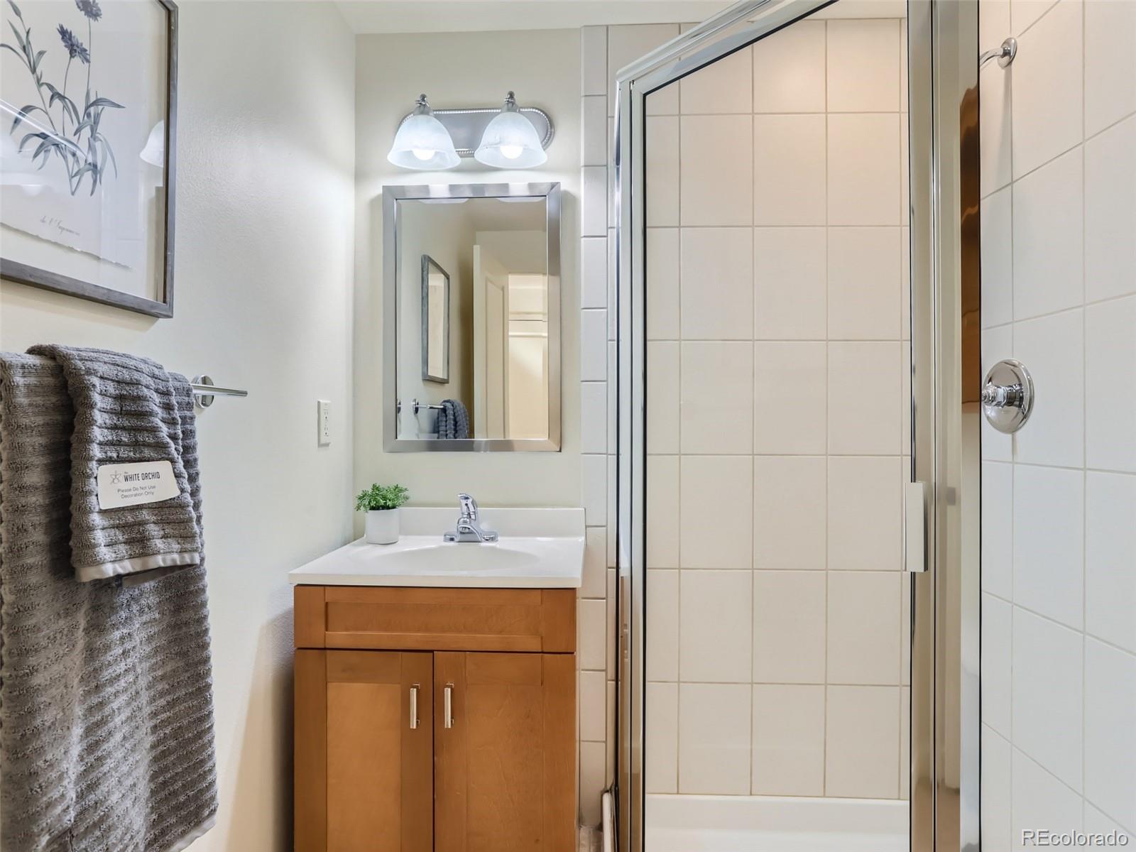 4645 Broadway, Unit B8 Boulder, CO 80304 - Photo 11 of 39 a bathroom with a sink a mirror and a shower