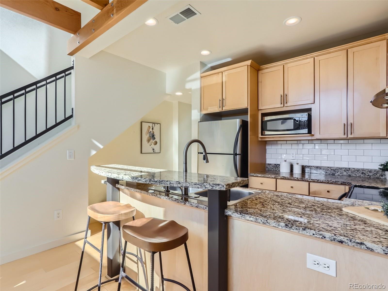 4645 Broadway, Unit B8 Boulder, CO 80304 - Photo 6 of 39 a kitchen with granite countertop a stove a sink and a microwave