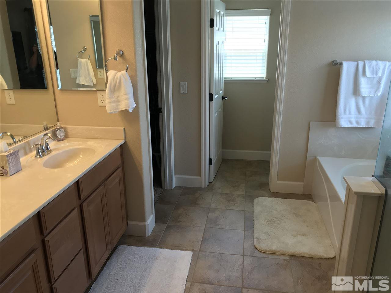 2055 Black Sand Drive Reno, NV 89521 - Photo 14 of 17 a spacious bathroom with a granite countertop sink a mirror and a bathtub