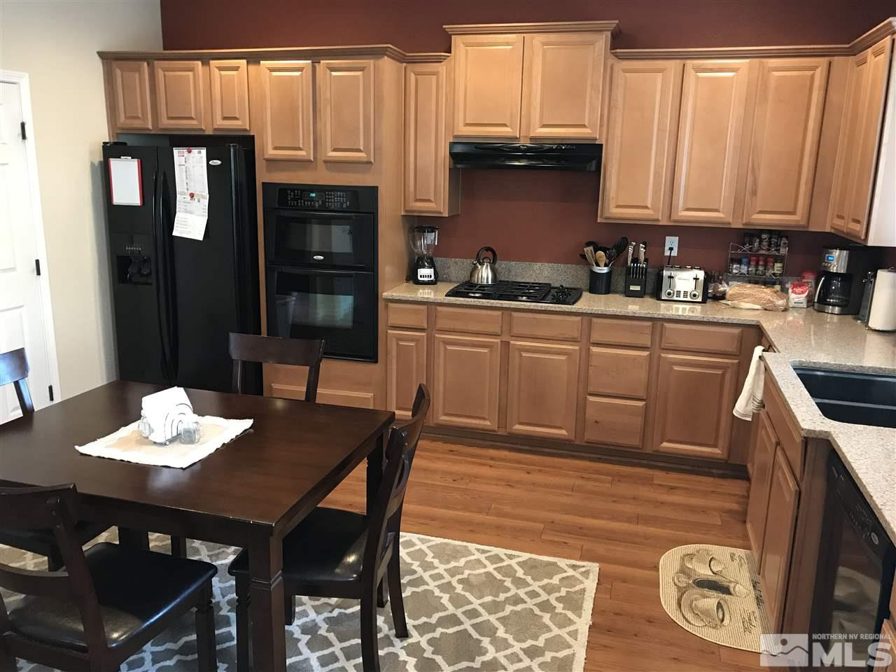 2055 Black Sand Drive Reno, NV 89521 - Photo 2 of 17 a kitchen with a kitchen island a stove a table and chairs in it
