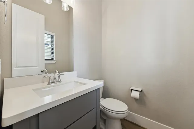 a bathroom with a sink a toilet and mirror