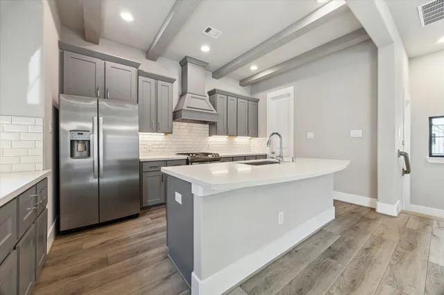 a kitchen with kitchen island a counter top space cabinets and stainless steel appliances