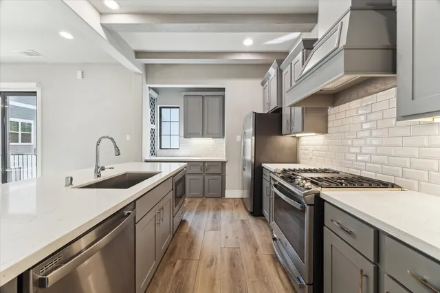 a kitchen with stainless steel appliances granite countertop a sink stove and cabinets
