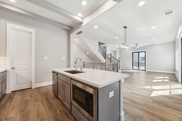 a kitchen with a sink a stove and wooden floor