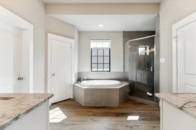 a spacious bathroom with a granite countertop tub sink and mirror