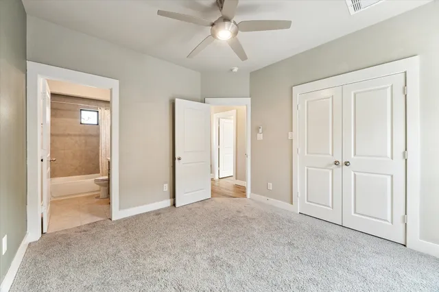 a view of empty room with window and ceiling fan