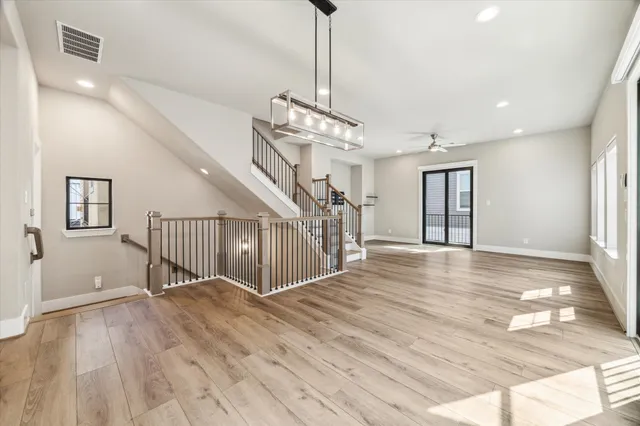 a view of a livingroom with wooden floor and stairs