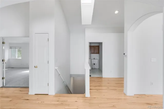 a view of a hallway with wooden floor and staircase