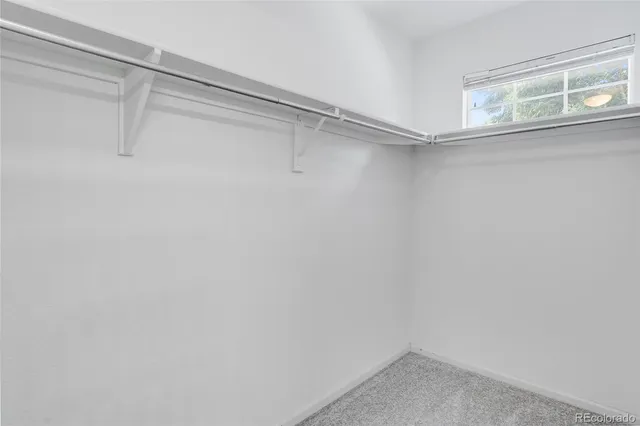 a small walk in closet with a window