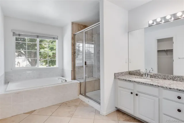 a spacious bathroom with a granite countertop tub sink and mirror