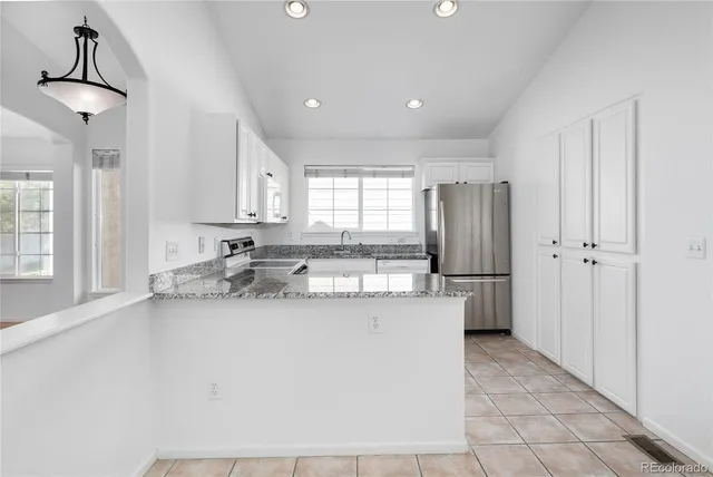 a kitchen with stainless steel appliances granite countertop a sink and a refrigerator