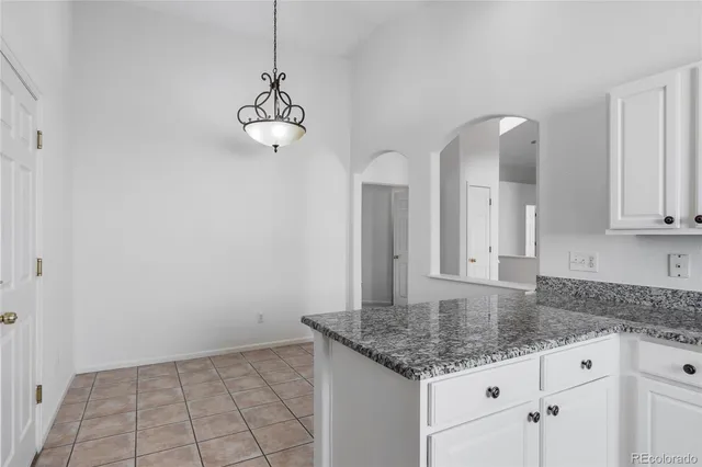 a kitchen with white cabinets and granite counter tops