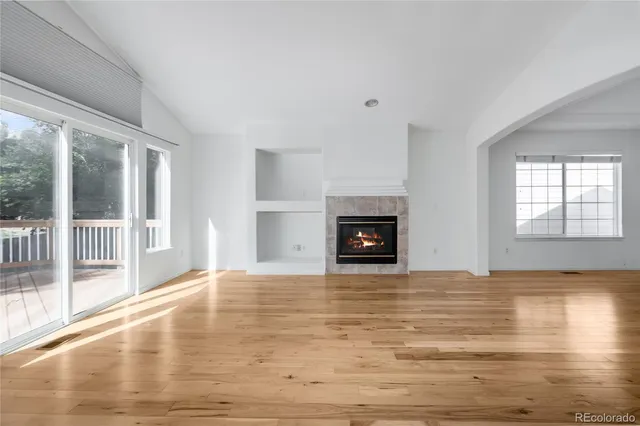 a view of empty room with wooden floor and fireplace