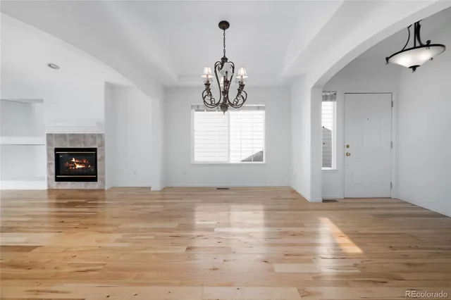 a view of empty room with wooden floor and fireplace