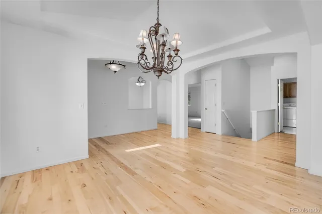 a view of an empty room with wooden floor and windows