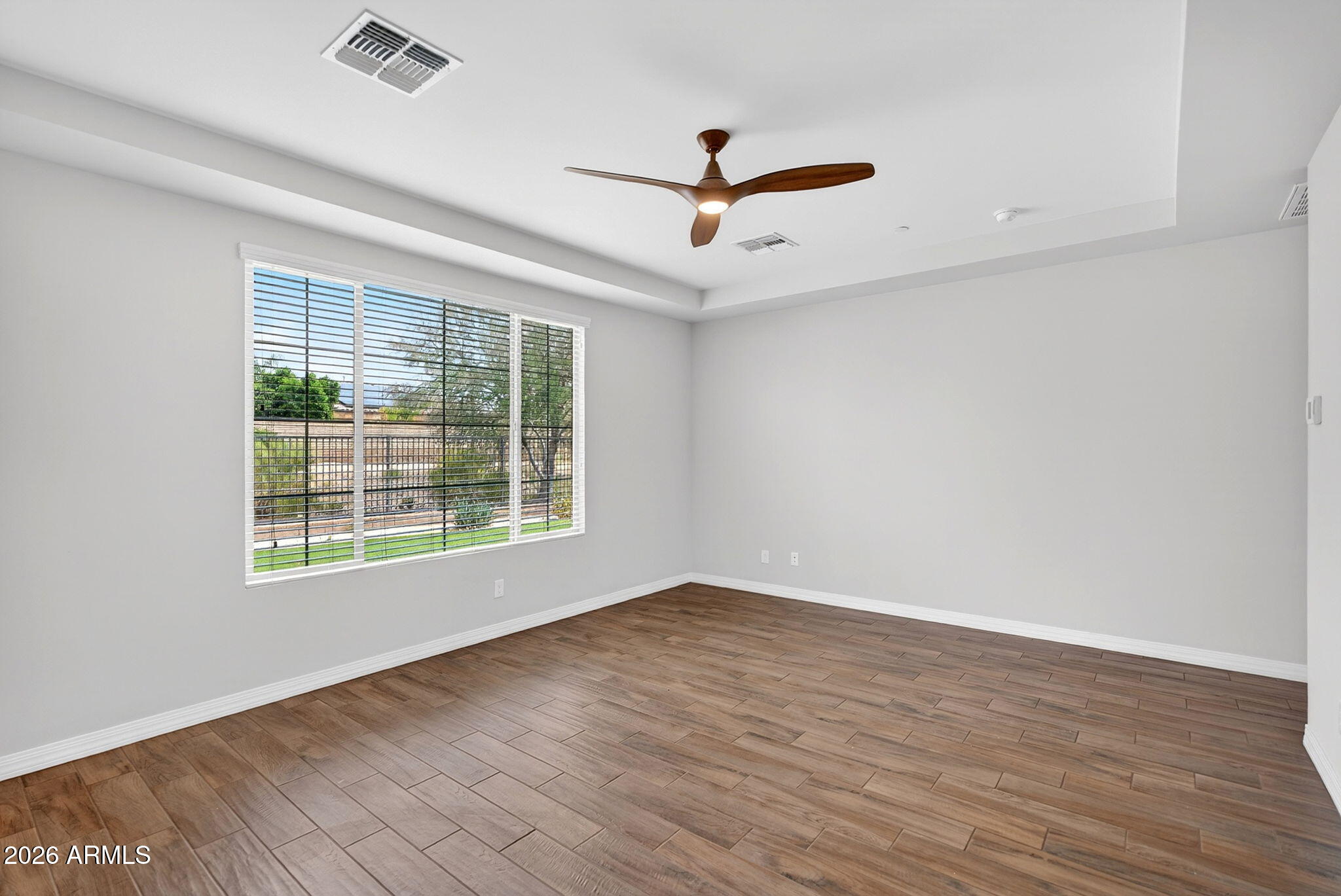 12124 West Peak View Road Peoria, AZ 85383 - Photo 16 of 38 wooden floor in an empty room with a window