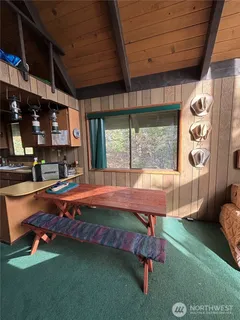a living room with a table chair and a large window