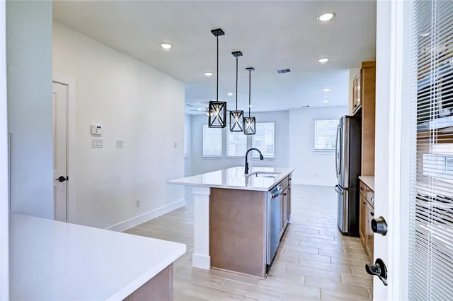 a kitchen with stainless steel appliances a sink and a refrigerator