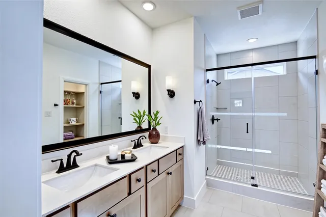 a bathroom with a double vanity sink mirror double and bathtub