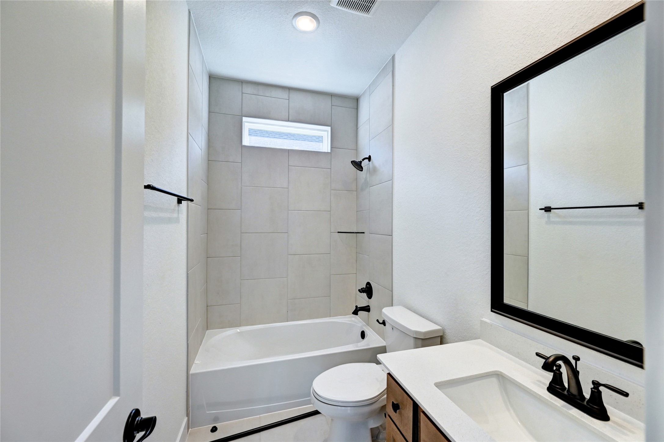 7643 Meadow Mouse Lane Katy, TX 77493 - Photo 30 of 35 a bathroom with a sink a toilet a mirror a bathtub and shower