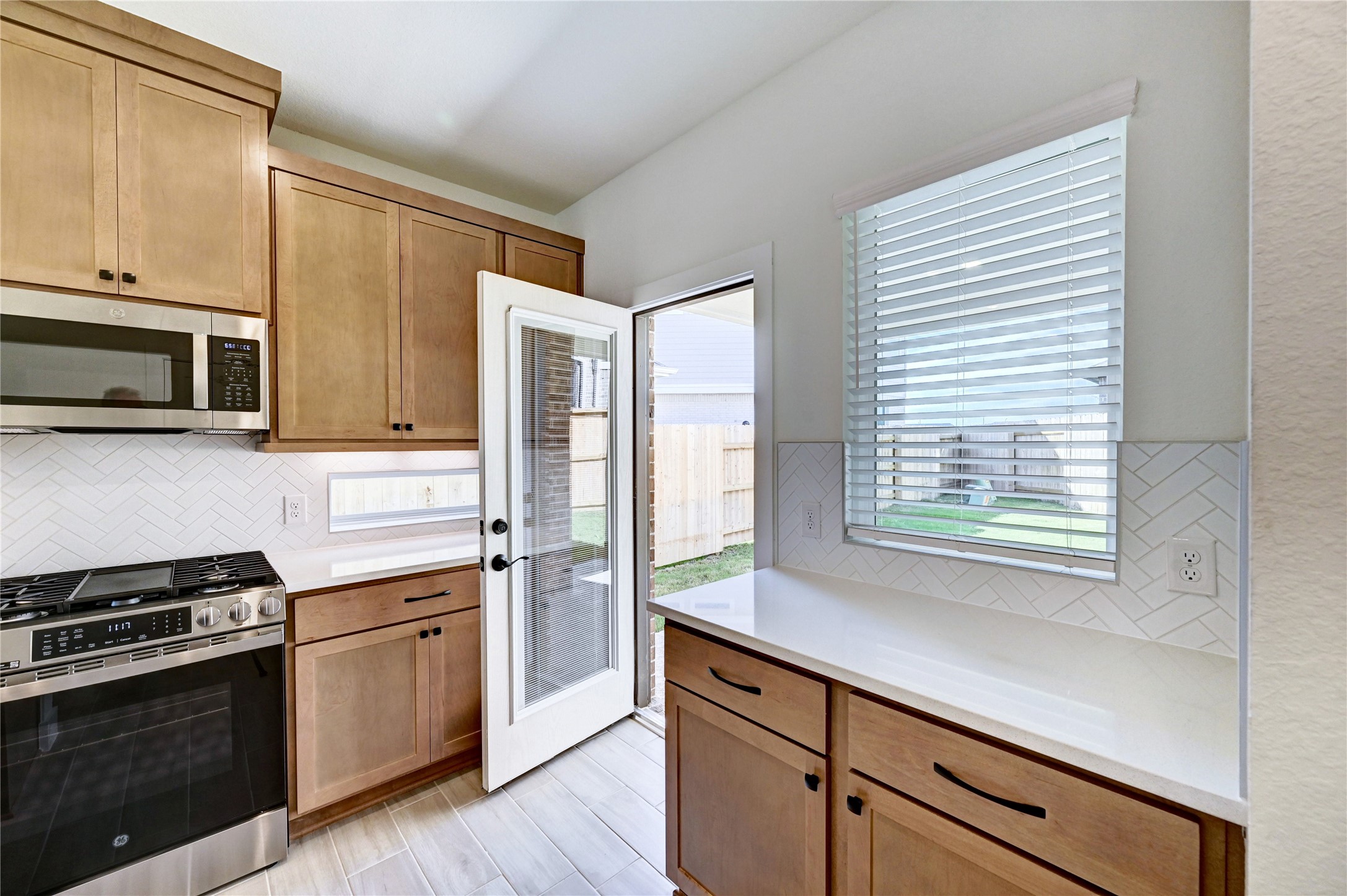 7643 Meadow Mouse Lane Katy, TX 77493 - Photo 10 of 35 a kitchen with stainless steel appliances a stove a sink and a microwave
