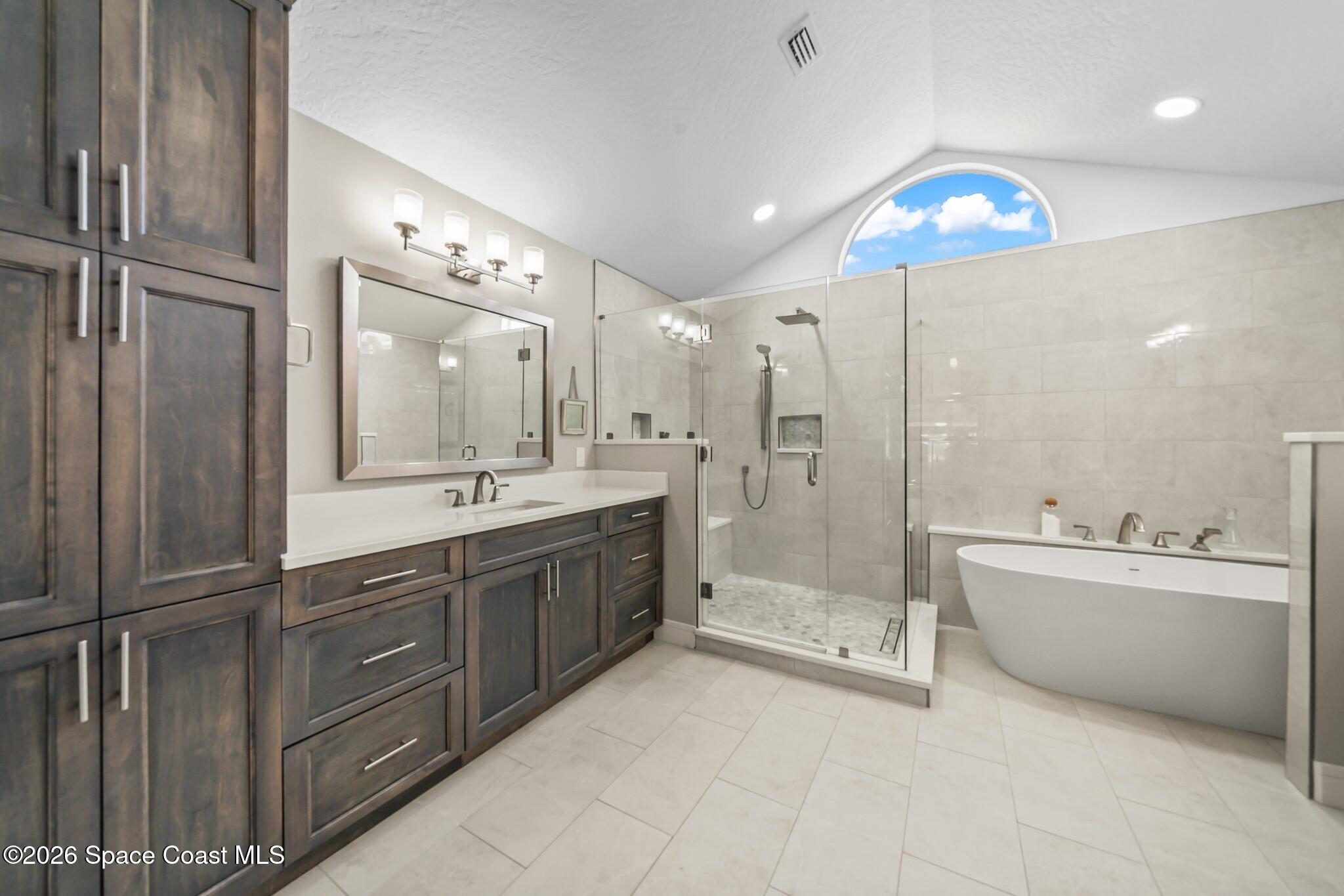 697 Spring Lake Drive Melbourne, FL 32940 - Photo 20 of 45 a large bathroom with a double vanity sink a large mirror and shower