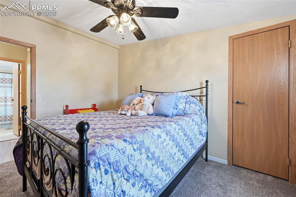 20985 McDaniels Road Calhan, CO 80808 - Photo 36 of 41 a bedroom with a bed and a chandelier