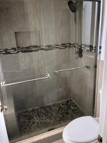 a bathroom with a toilet and a shower
