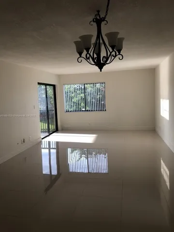a view of a room with a ceiling fan and window