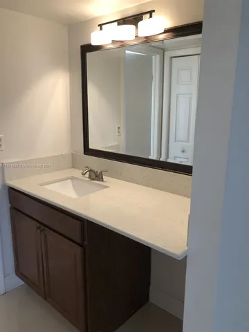 a bathroom with a sink vanity and a mirror